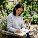 Parent writing in autism journal at kitchen table