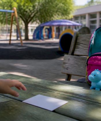 Child's hand pointing at communication card