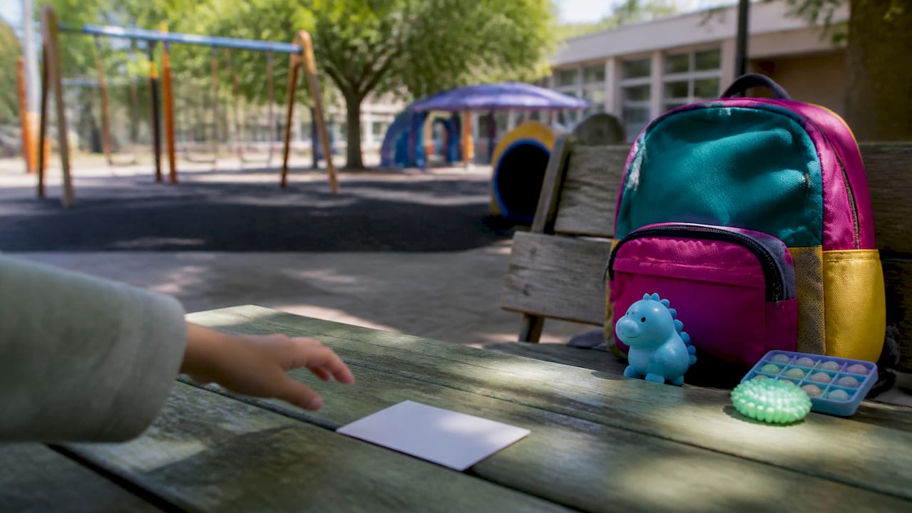 Child's hand pointing at communication card